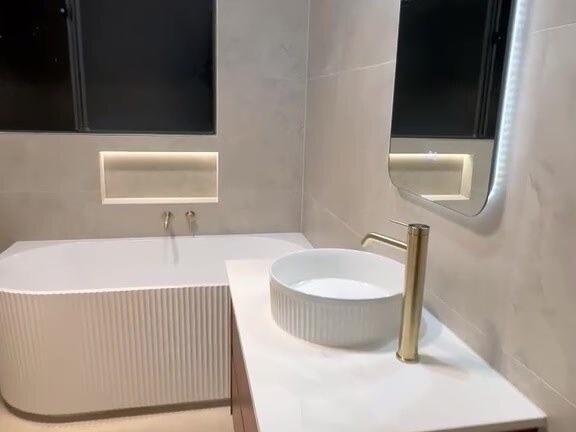 Fluted freestanding bath with backlit mirror