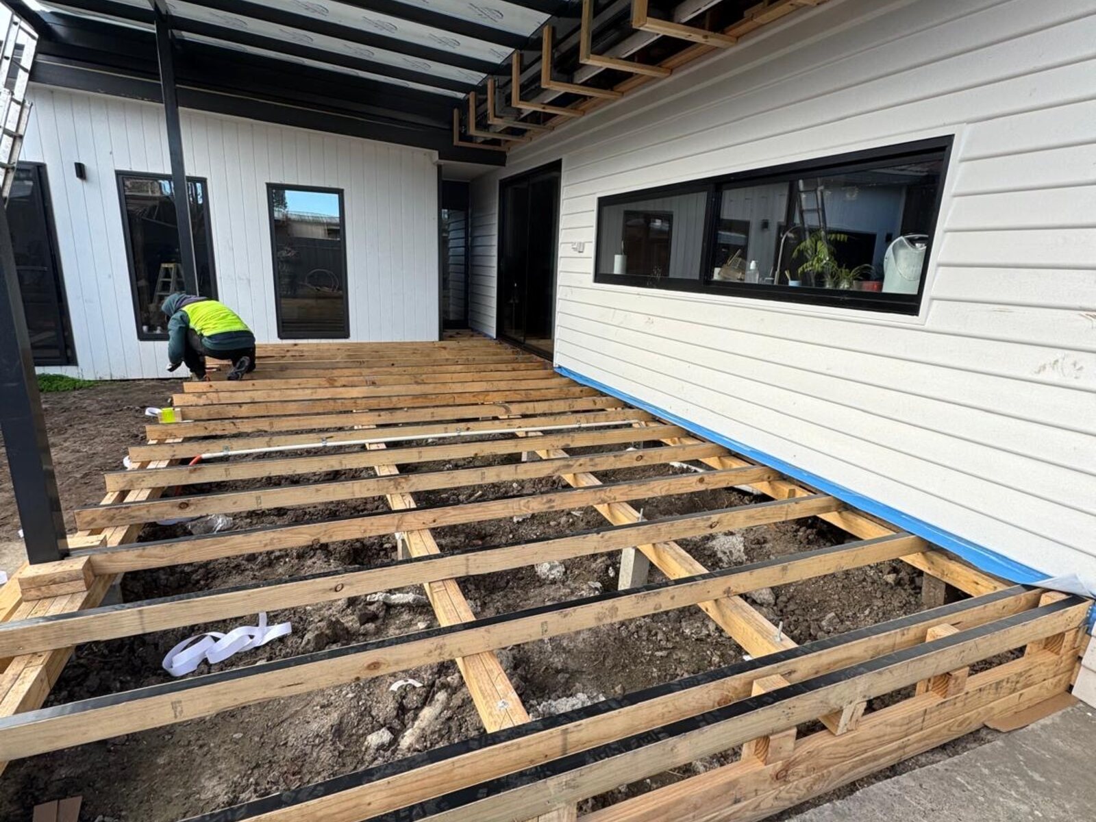Deck joists installed beside new picture window